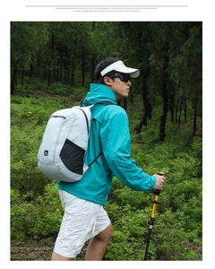Outdoor light gray backpack in action during a forest hiking trip with trekking poles
