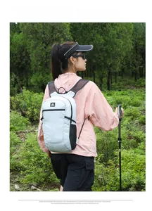 Outdoor lightweight hiking backpack shown in use with trekking poles on scenic mountain trail