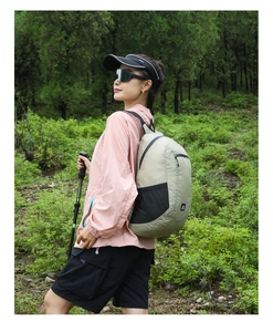 Outdoor light khaki backpack shown on a female model in a scenic mountain setting