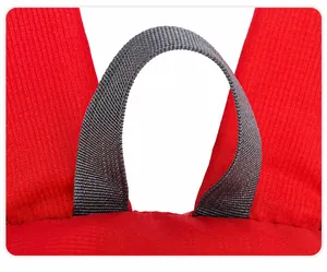 Detail view of the top gray webbing handle and red ripstop nylon fabric of the backpack