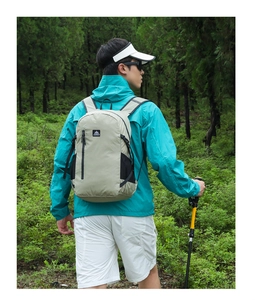 Detail of grey-green hiking backpack with side mesh pocket and zip in forest setting