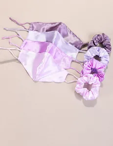 Close-up of cotton face masks and matching satin scrunchies in purple gradient colors