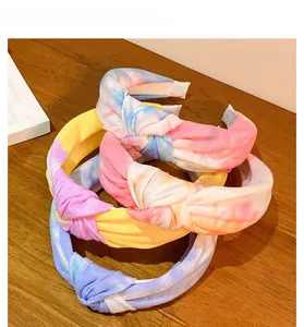 Detail view of a set of four wide tie-dye knot headbands with colorful batik patterns