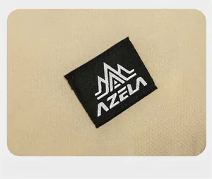 Dettaglio ravvicinato del logo AZELA ricamato su resistente tessuto beige