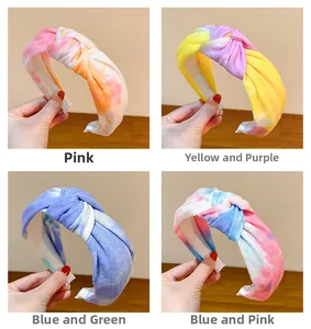 Detail view of four colorful tie-dye twisted headbands in soft textured knit fabric