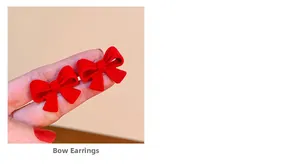 Gros plan de boucles d'oreilles nœud rouge floqué montrant la texture et la taille réelle