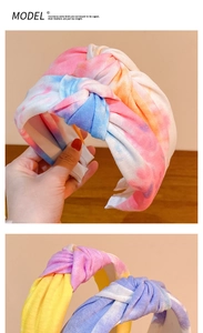 Detail of wide tie-dye knotted headband showing colorful knit fabric texture and knot