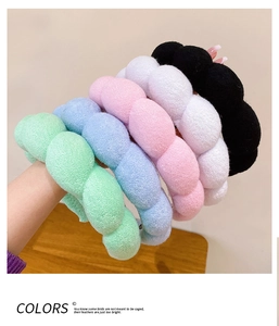 Detail von fünf bunten Spa-Stirnbändern in Minze, Blau, Rosa, Weiß und Schwarz aus Plüsch