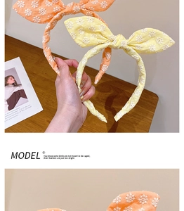 Détail de serre-têtes oreilles de lapin brodés de fleurs en tissu rose et beige