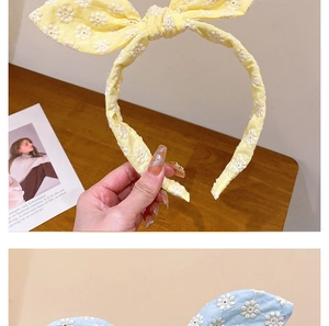 Détail de serre-têtes brodés avec nœuds en tissu jaune et bleu clair à fleurs