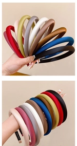 Detail view of handmade satin sponge headband showing soft silk texture and hand-made label