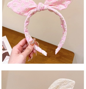 Détail de serre-têtes à nœud avec broderie florale en tissu rose et crème pour femme