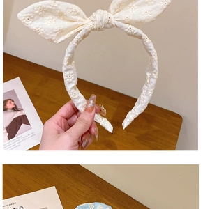 Détail de la broderie anglaise blanche sur un serre-tête avec nœud élégant