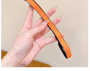 Détail d'un bandeau de sport orange élastique avec bordure noire et texture tissée