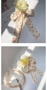 Détails d'un ensemble bandeau et chouchou en mousseline crème avec imprimé cerise doux