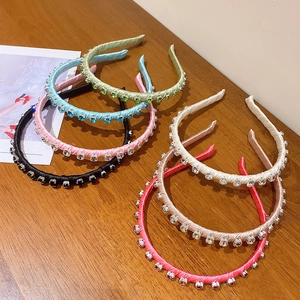 Elegant rhinestone padded headbands set in various silk satin colors on wooden surface