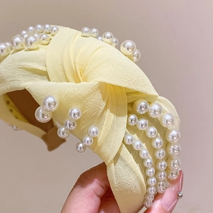 Eleganter gelber Haarreif mit Knotendetail und weißen Perlen im Retro-Design