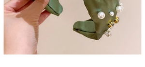Detail eines dunkelgrünen Satin-Hairreifs mit weißen Perlen und Glitzersteinen
