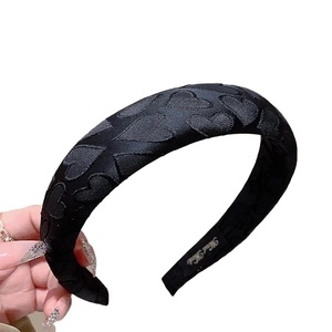 Satin black padded headband with heart pattern texture and handmade inner label