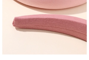 Close-up of pink knitted ribbed texture and fine stitching on a minimalist headband