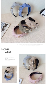 Detail of twisted wide headbands featuring white pearls and golden beads embellishments