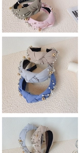 Detail of twisted wide headbands featuring white pearls and gold beads in soft colors