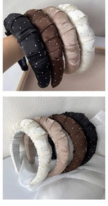 Detail of pleated satin headbands with rhinestones in black, brown, and cream