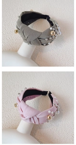 Detail of wide knotted headbands with pearls and metal beads in olive green and light pink