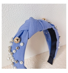 Detail of light blue denim fabric headband featuring white pearls and mixed metal beads