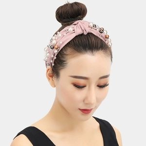 Fashionable pink twisted headband with multi-color faux pearls on matte fabric