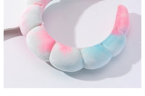 Primer plano de la textura de la diadema de terciopelo rosa y azul tie-dye para el cuidado facial