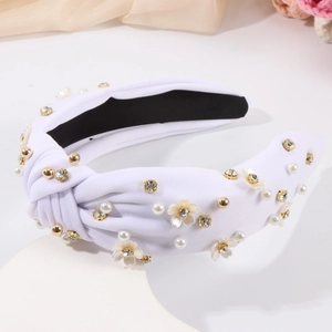 Détail d'un serre-tête noué blanc orné de perles, strass et fleurs en relief