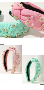 Dettaglio cerchietto floreale con perle e strass su tessuto color pastello