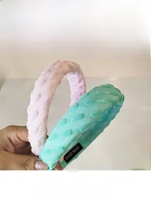 Gros plan de serre-têtes texturés rose et vert avec étiquettes faites à la main