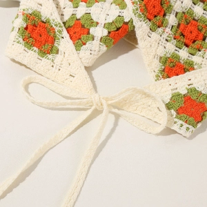 Close-up of handmade crochet granny square bandana with green and orange floral patterns