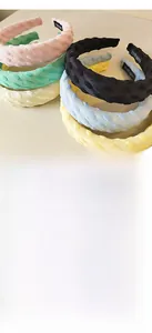 Gros plan de serre-têtes en tissu texturé de différentes couleurs avec étiquette faite main