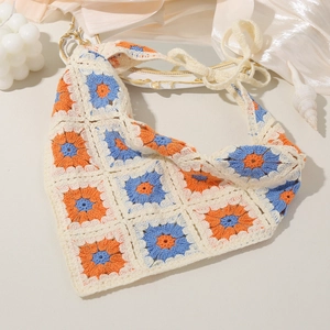 Detailed macro view of crochet floral triangle headscarf with orange and blue knit petals