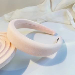Macro detail of the light pink textured fabric on a thick padded headband for women