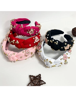 Detail view of colorful cross knot headbands with faux pearls, rhinestones, and pink hearts