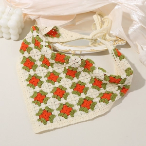 Detail of handmade crochet floral bandana featuring granny square patterns and cream cotton
