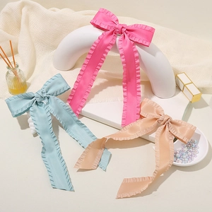 Elegant satin bow hair clips with ruffled edges in pink, blue and champagne colors