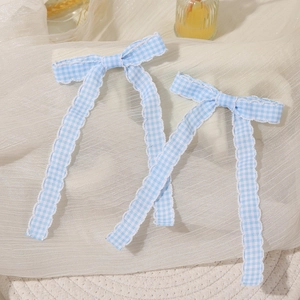 A pair of blue and white plaid bow hairpins with long ribbons and a fresh style