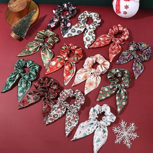 Chouchous de Noël en satin avec oreilles de lapin et motifs festifs sur fond rouge