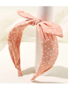 Dettaglio di un cerchietto rosa a pois con un simpatico fiocco a forma di orecchie