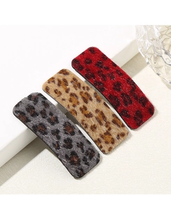 Detailed view of three plush leopard print hair clips in red, khaki and grey colors