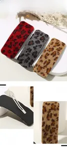 Detailed view of leopard print hair clips showing plush texture and metal snap clip backings