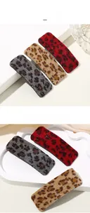 Detail of leopard print rectangular hair clips in red, grey, and khaki velvet texture