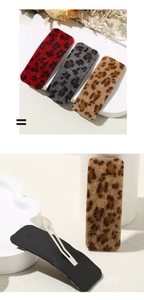 Detail of leopard print hair clips with plush texture and silver metal snap closure