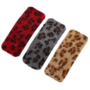 Three-piece leopard print plush hair clips in red, grey, and brown on white background