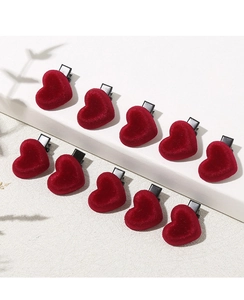Detailed view of ten deep red velvet heart-shaped hair clips in an organized layout